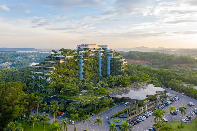 Tòa Forest in the Sky phủ cây xanh ở Flamingo Đại Lải nhìn từ trên cao, phía xa là hồ và đồi