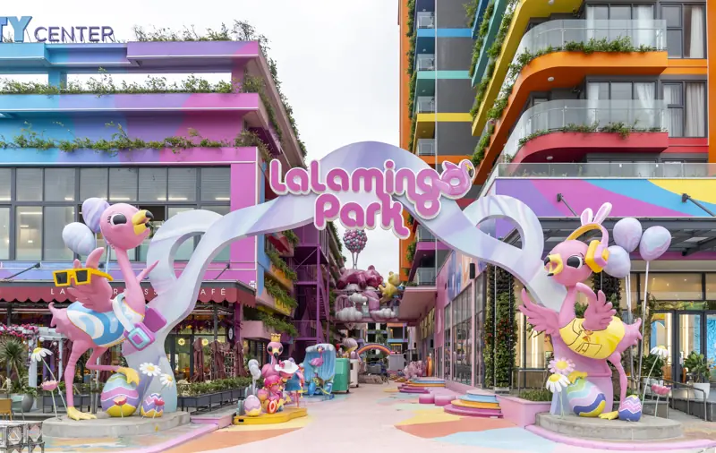 Cổng Lalamingo Park với hai tượng hồng hạc lớn, phố đi bộ màu hồng giữa các tòa nhà nhiều màu