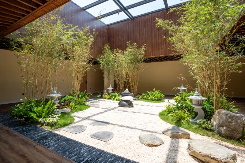 Khu vườn Nhật sỏi trắng, đá và tre dưới mái kính trong khu onsen