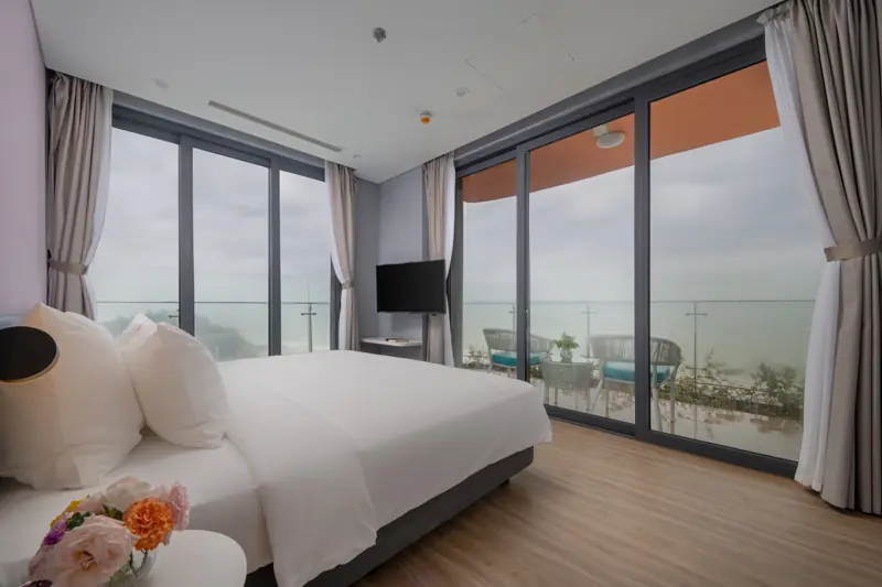 Phòng ngủ căn Premier Residence 1 phòng ngủ, cửa kính kịch trần mở ra ban công nhìn biển