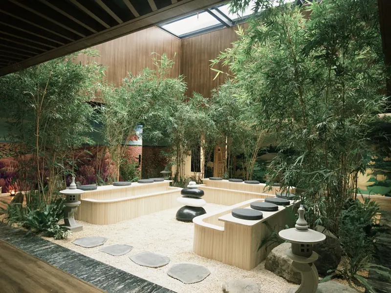 Khu ngâm chân thảo dược với ghế gỗ, đèn đá giữa vườn tre ở SEVA Onsen & Spa Flamingo Hải Tiến