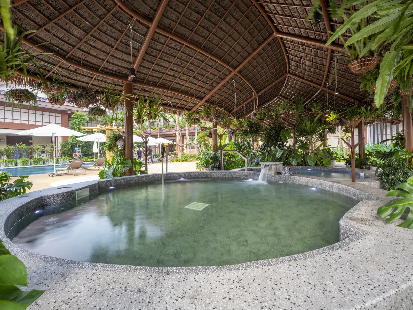 Bể onsen ngoài trời dưới mái lá, xung quanh cây xanh, ở Flamingo Tân Trào