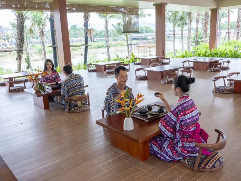 Khách mặc áo thổ cẩm ngồi bàn thấp thưởng trà ở Nguyệt Trà Viên, Flamingo Tân Trào