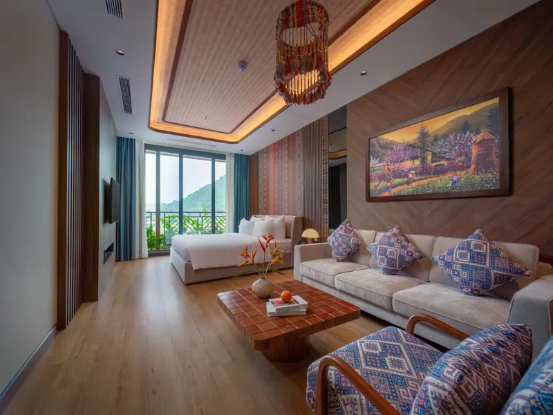 Deluxe Residence: phòng khách sofa, bàn trà gỗ và giường đôi phía sau