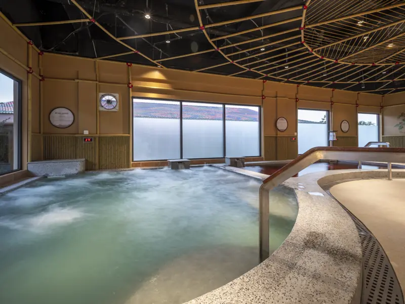 Bể onsen trong nhà sủi bọt, trần tre, cửa kính lớn