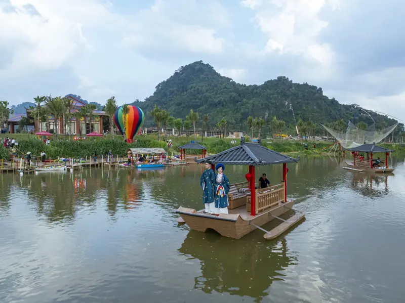 Thuyền mái đình trên sông Phó Đáy cạnh resort, phía sau là núi đá xanh